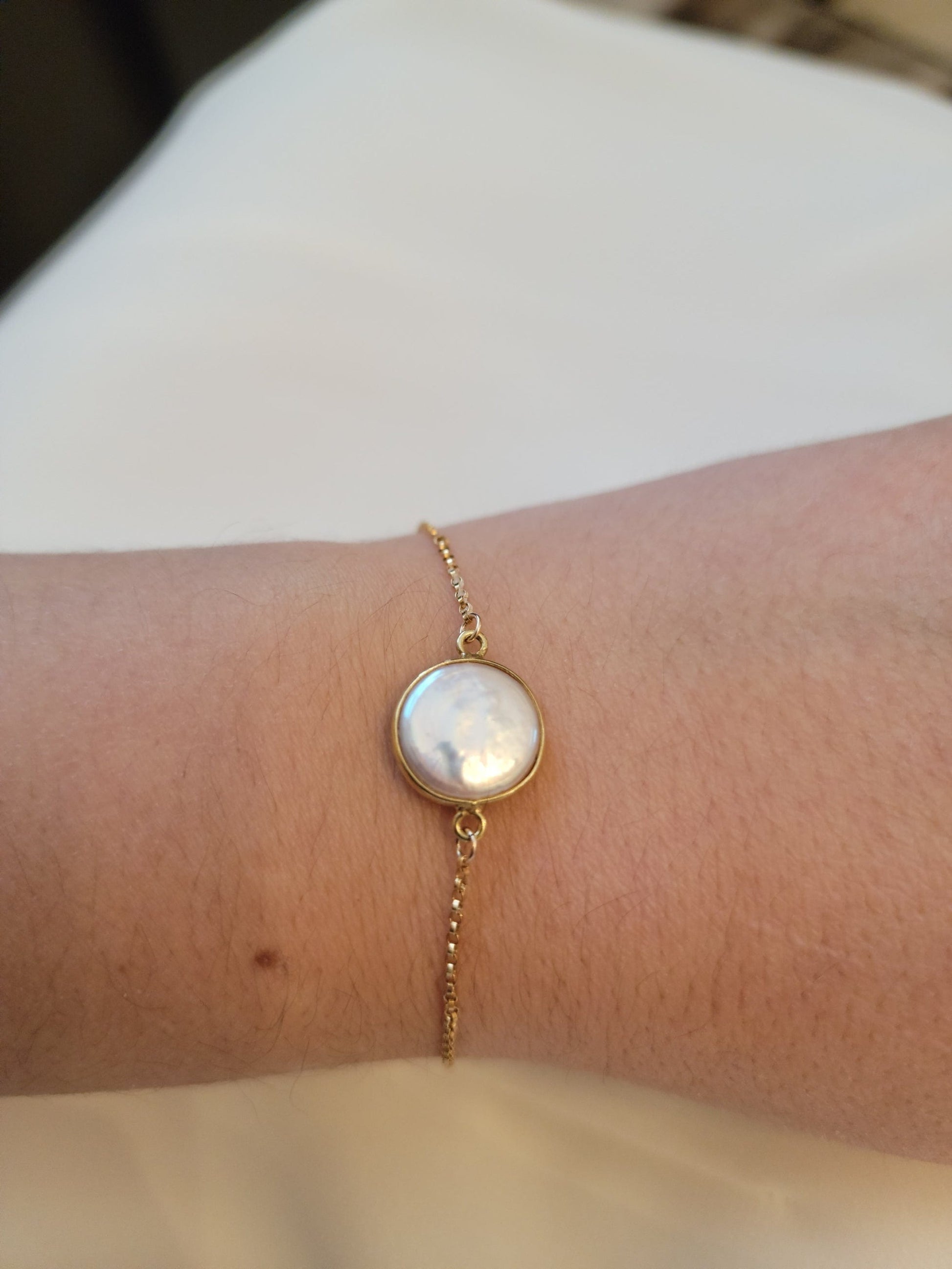 Coin pearl with gold plated bezel hand assembled on gold filled adjustable bracelet. 