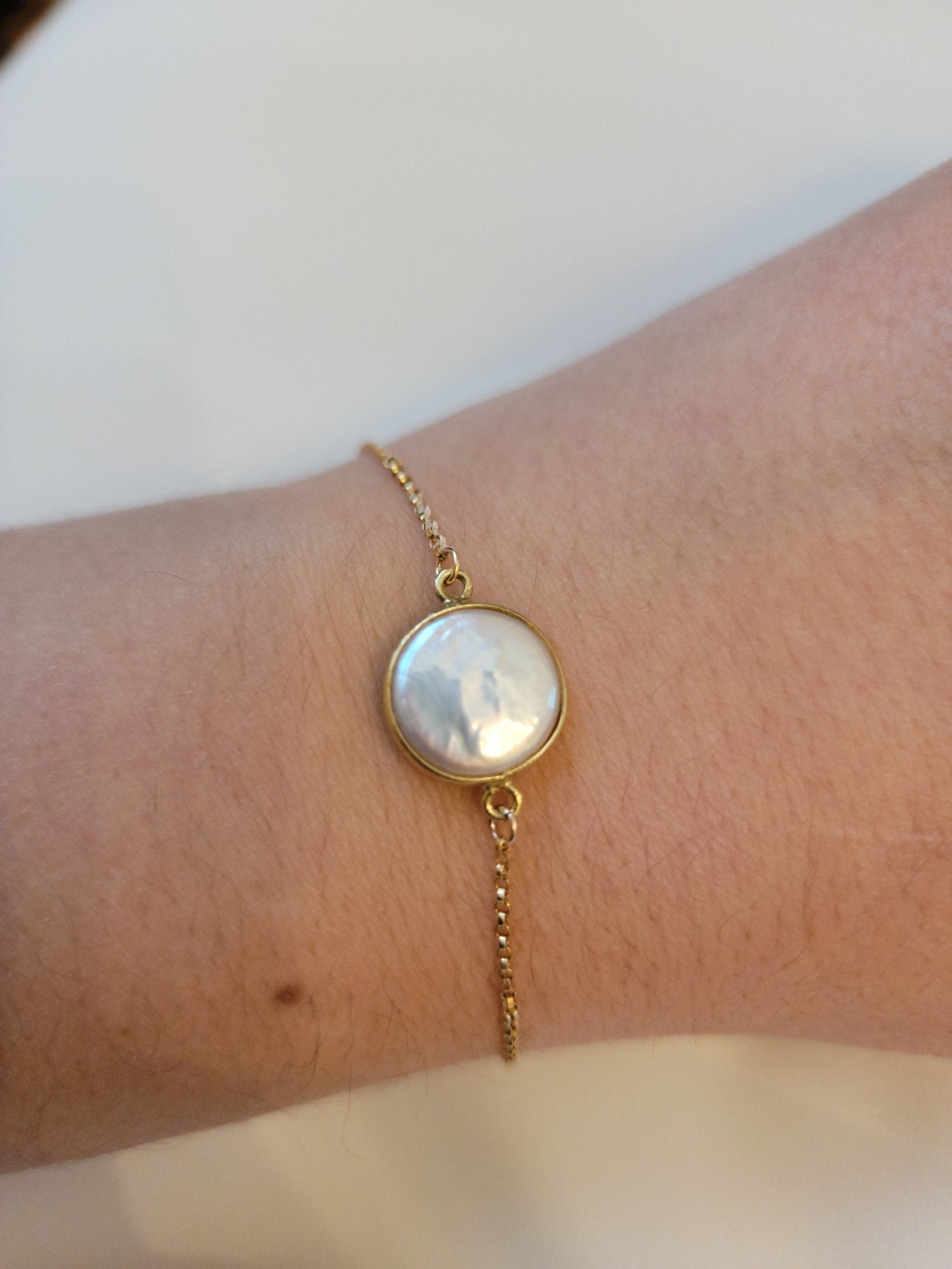 Coin pearl with gold plated bezel hand assembled on gold filled adjustable bracelet. 