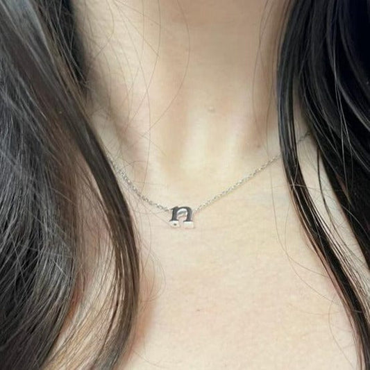 Dark-haired woman wearing the Seren and Skye Initial Necklace in N Sterling Silver. 